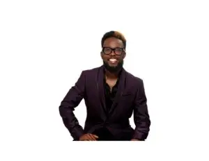 Jalal Wilson smiling confidently in a purple blazer with glasses